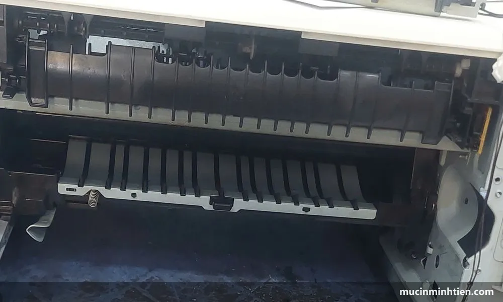 Tay kỹ thuật viên cầm bao lụa lô sấy trước máy in đã mở cụm sấy