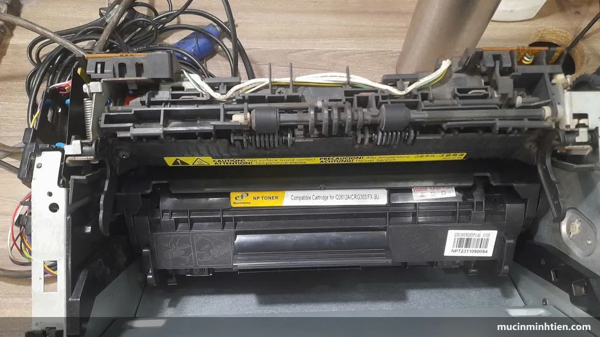 Lắp hộp mực vào khoang máy in laser, thấy nhãn cảnh báo trên hộp